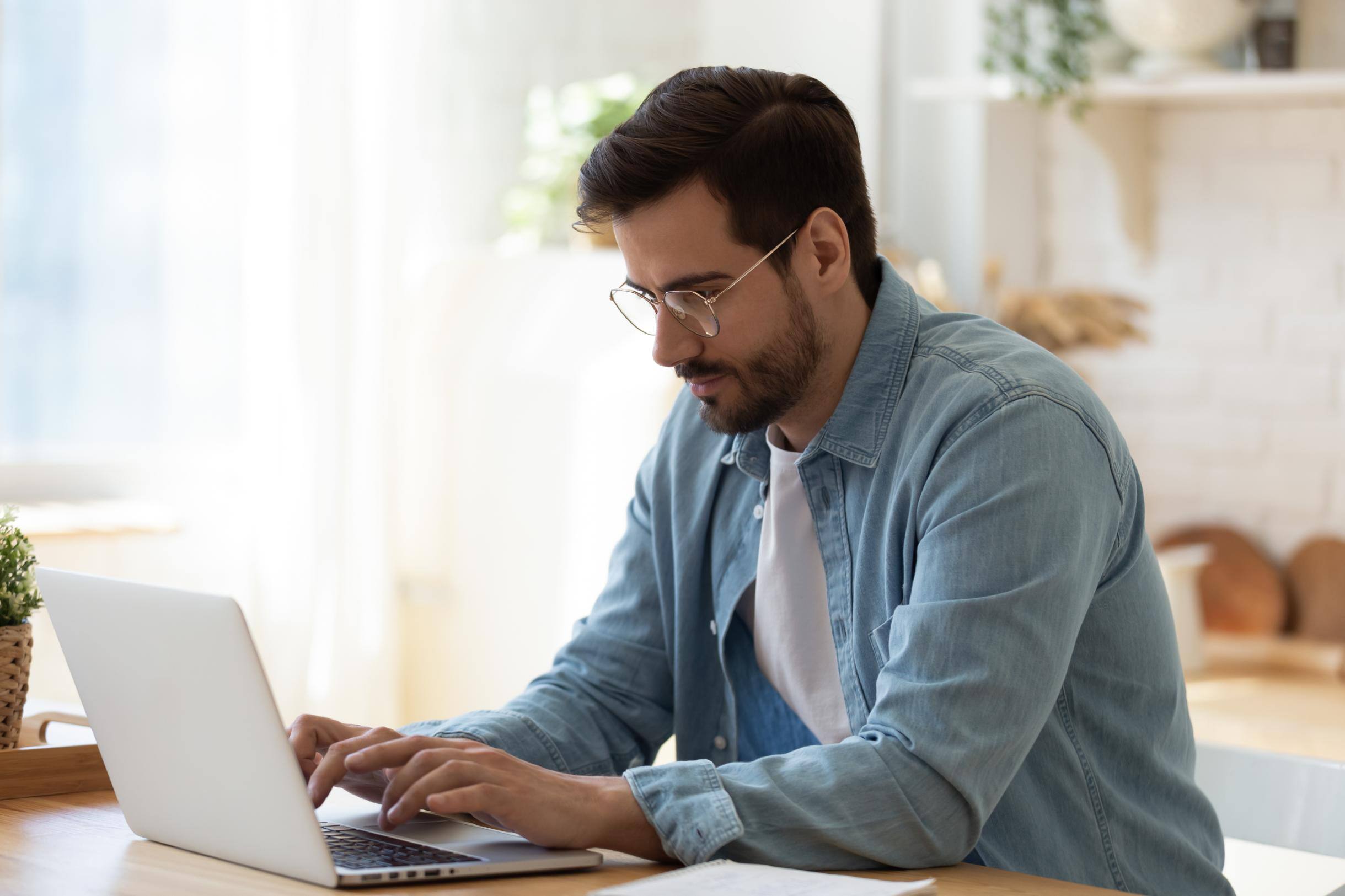 Business man working on a laptop at a table from