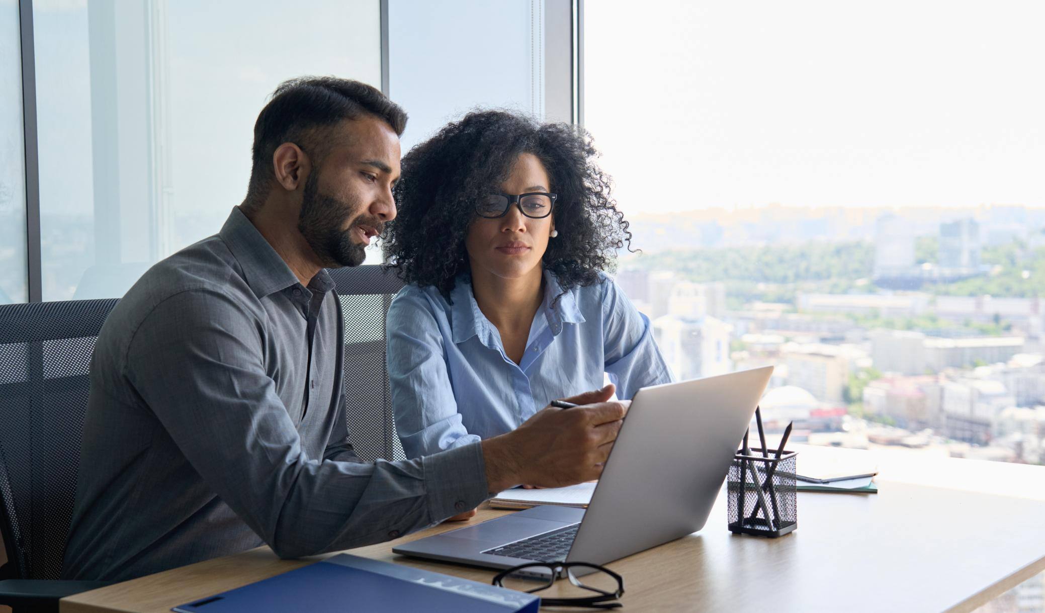 Business people working on a laptop at a table together