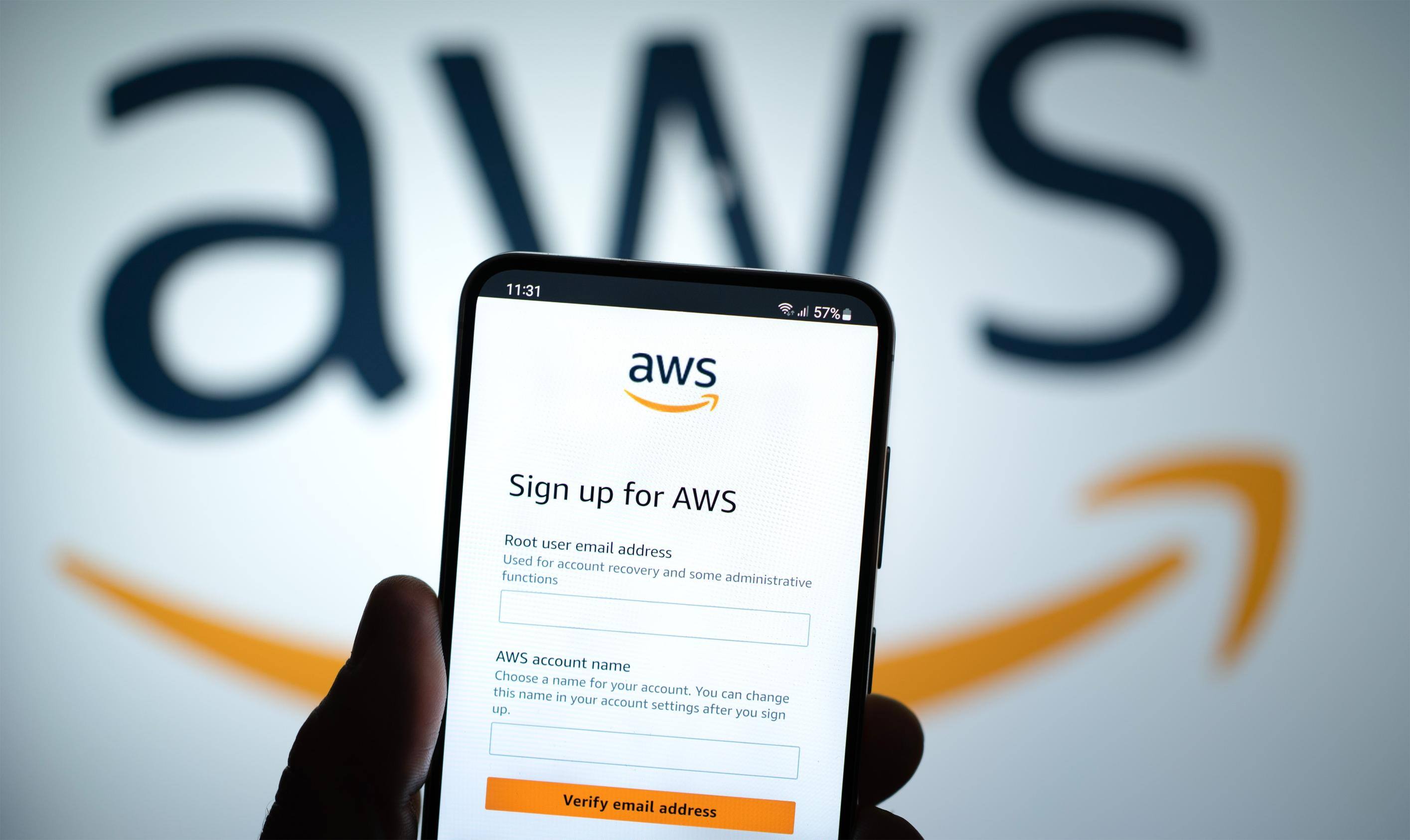 AWS logo on phone in front of a computer screen