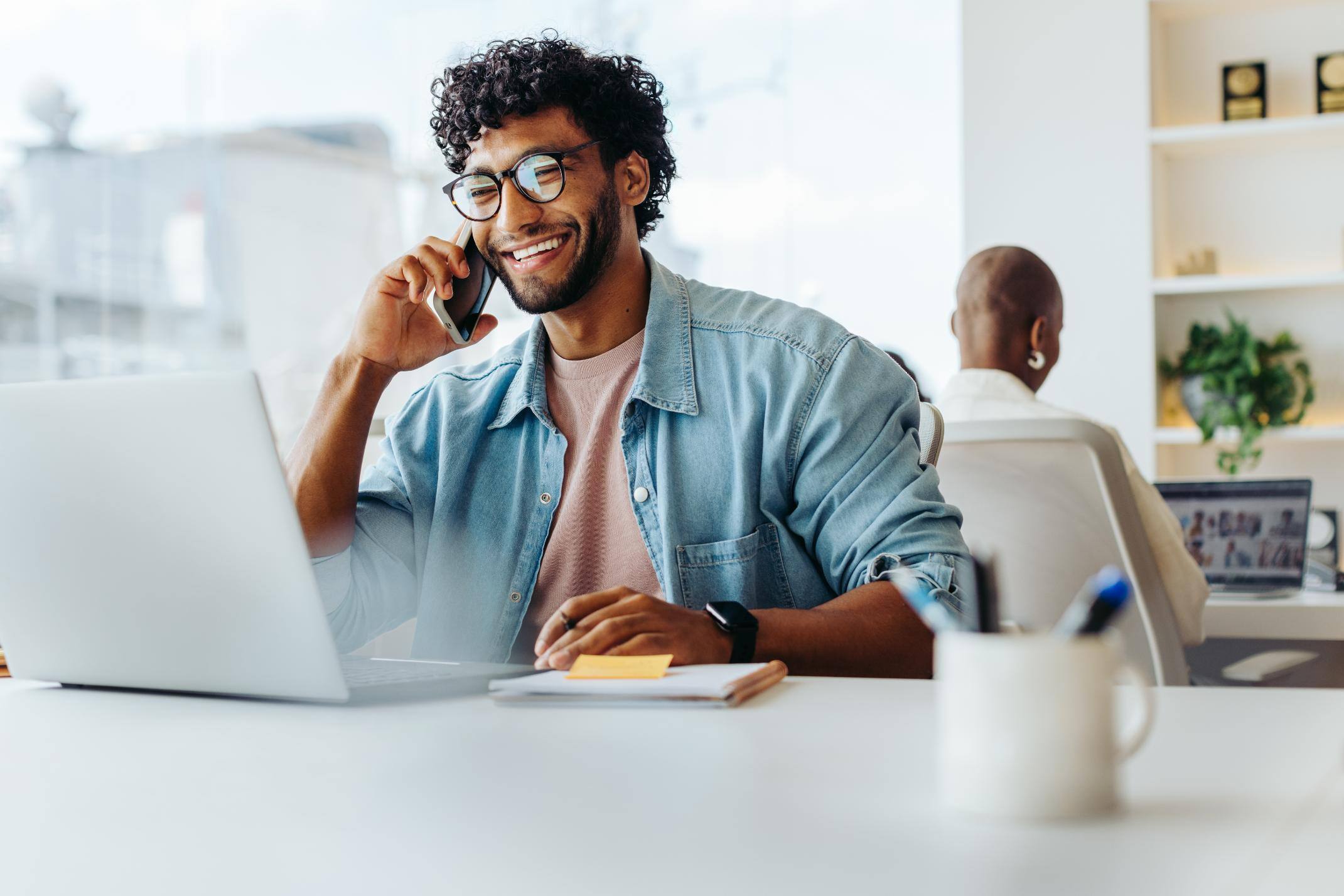 Business man talking on phone while sitting at a desk