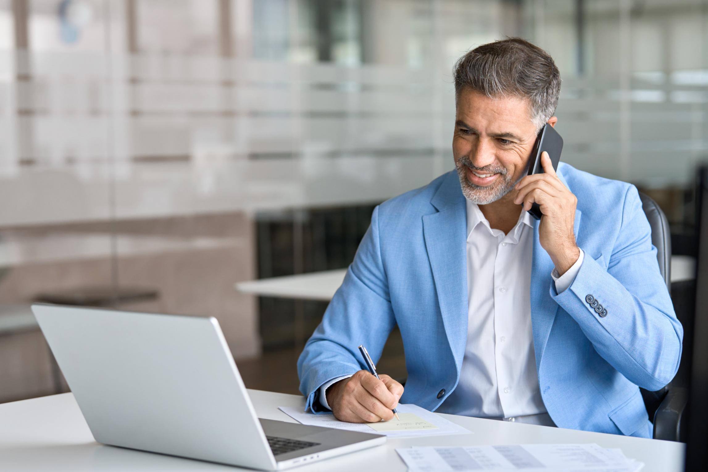 Business man talking on phone at a desk