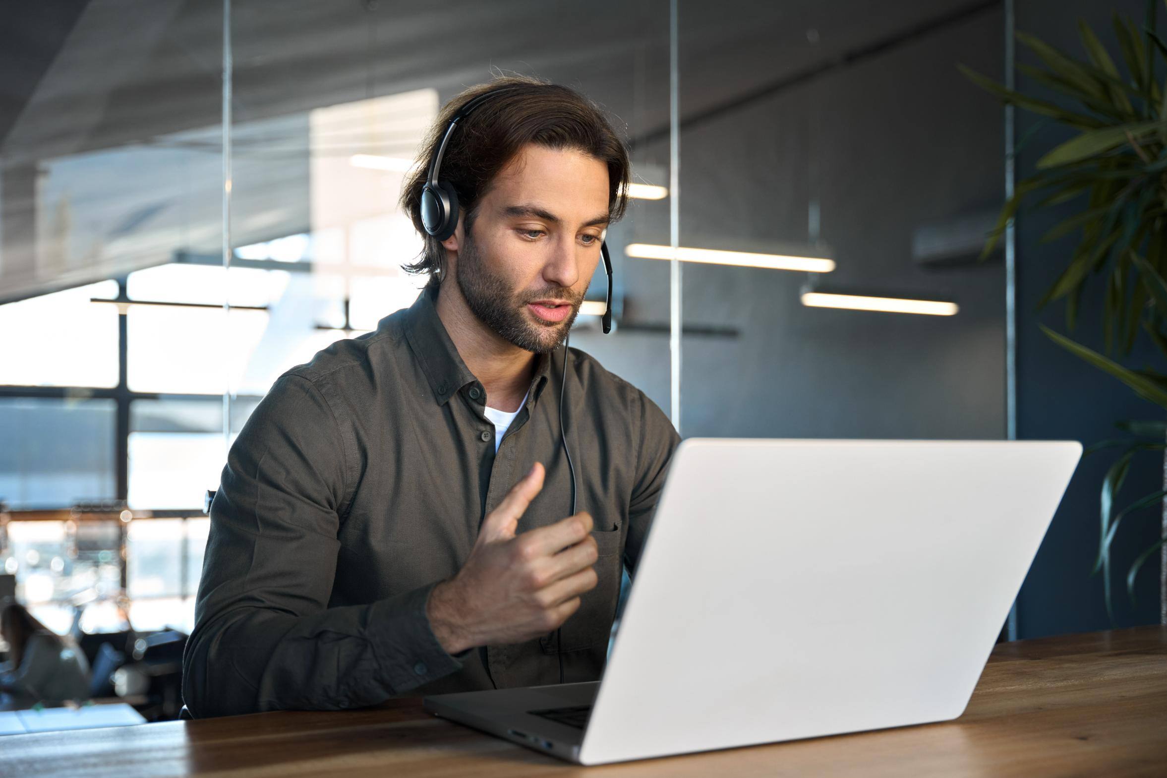 Business person talking on a headset while working on a computer